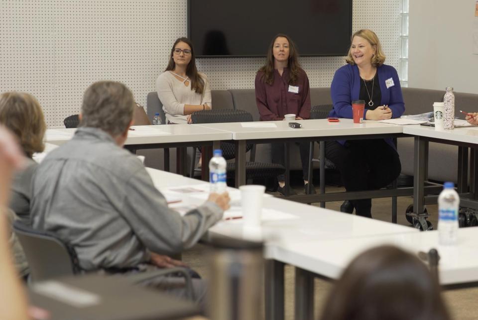 Holly Dabelko-Schoeny at a conference table speaking to five other individuals.