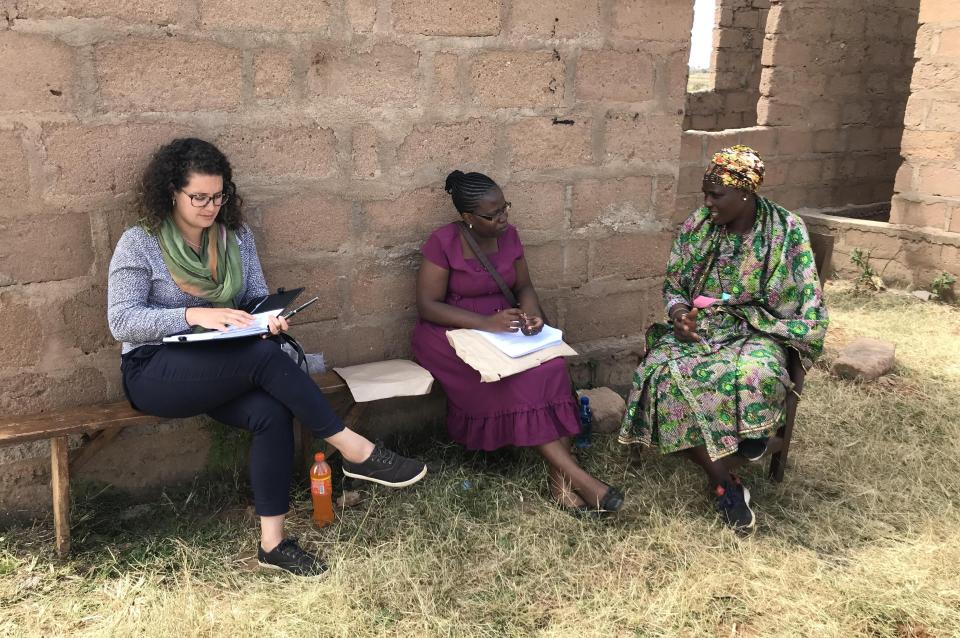Mary Rodriguez in Tanzania sitting with two women.